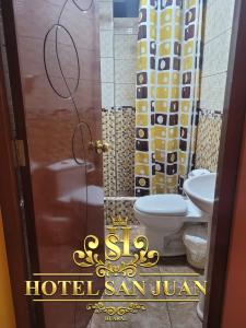 ein Badezimmer mit zwei WCs und ein Schild, das Hotel San Juan liest in der Unterkunft Hotel San Juan Huaral in Huaral