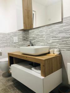 un bagno con un lavandino bianco su un bancone di legno di Guest house pura vida a Verona