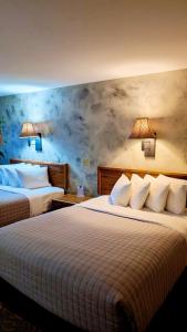 um quarto de hotel com duas camas e duas lâmpadas em Browns Canyon Inn em Salida