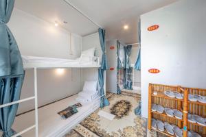 Central Sapa Serenity Homestay في سابا: غرفة مع سرير بطابقين وسرير أطفال