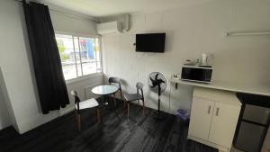 uma cozinha com uma mesa e cadeiras e um micro-ondas em Cairns City Motel em Cairns