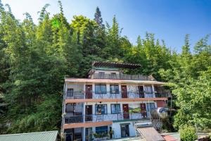 a tall building with a balcony and trees at Central Sapa Serenity Homestay in Sa Pa