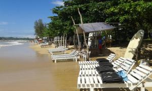a row of white chairs on a beach with water at Kaween Homestay in Weligama