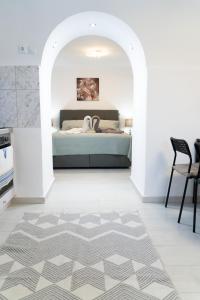 sypialnia z łóżkiem w białym pokoju w obiekcie Pigadia Central w mieście Karpatos