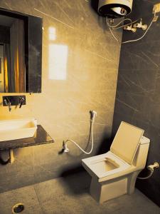 a bathroom with a white toilet and a sink at Hotel Ambience Dilli 37 At - Near IGI Airport in New Delhi