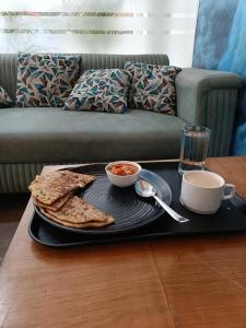 um tabuleiro com um prato de comida numa mesa em Hotel Ambience Dilli 37 At - Near IGI Airport em Nova Deli