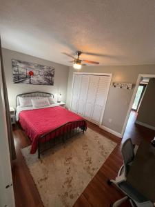 a bedroom with a bed with a red comforter at Private Room - Free Parking - Kendall Area in Miami