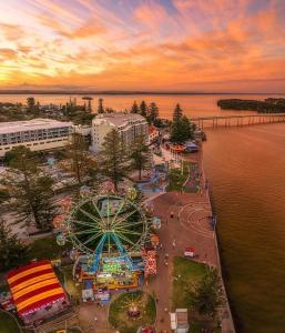 an amusement park with a carnival and a ferris wheel at Venus Resort in The Entrance