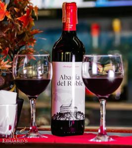 butelkę wina obok dwóch kieliszków czerwonego wina w obiekcie Hotel Eduards Suite w mieście Macuto