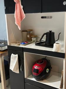 a kitchen counter with a red helmet in a cupboard at Hygge Home 