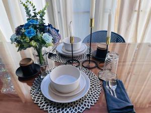 a table with plates and cups and a vase of flowers at Hygge Home 