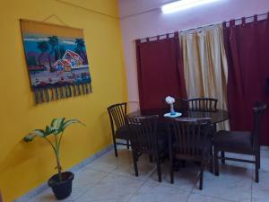 a dining room with a table and chairs and a painting at Habib Inn in Srīvardhan