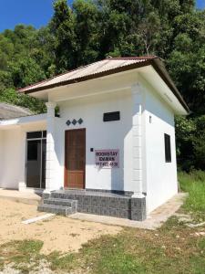 a small white building with a sign on it at Tiny House Idaman Kuala Terengganu with Private House in Kuala Terengganu