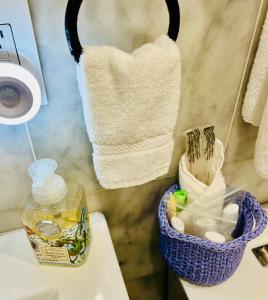a bathroom with a basket of towels on a sink at Eleni’s Charming Studio in North Beach
