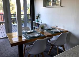 een eettafel met stoelen en een houten tafel en een tafel bij 9 Alpine Avenue in Hanmer Springs +10 foto's