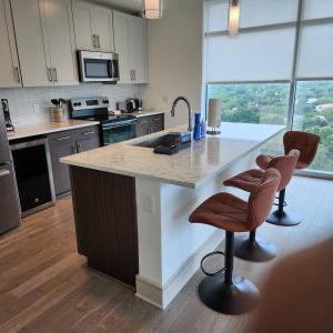 a kitchen with a large island with two bar stools at Latitude Med Center in Houston