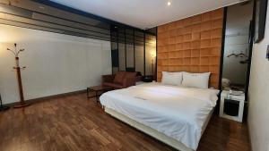 Gimhae Business Hotel K في Gimhae: غرفة نوم مع سرير أبيض كبير في غرفة