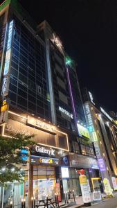 a tall building with lights on the side of a street at Gimhae Business Hotel K in Gimhae