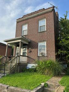 an old brick house with a porch and stairs at Keur Koura in The Ville in Saint Louis