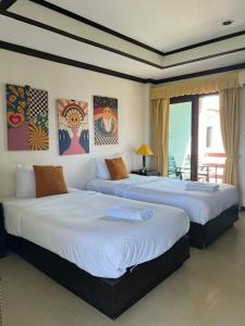 a bedroom with two beds and a balcony at Samui Seabreeze Place in Lamai