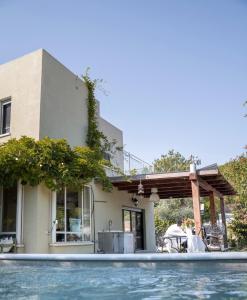 a house with a swimming pool in front of a house at Ettys Villa in Giv'at Yo'av