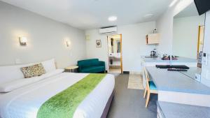 pokój hotelowy z dużym łóżkiem i kuchnią w obiekcie Bella Vista Motel Whangarei w mieście Whangarei