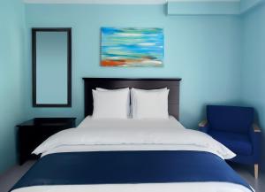 1 dormitorio azul con 1 cama y 1 silla azul en Granby Motel, en South Hadley