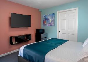 a bedroom with a bed and a flat screen tv at Granby Motel in South Hadley