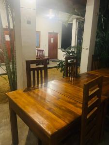 una mesa de madera y sillas en una habitación en Moxy Bay Arugambay en Arugam Bay