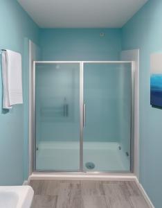 um chuveiro com uma porta de vidro na casa de banho em Granby Motel em South Hadley