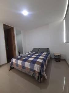 1 dormitorio con 1 cama con manta azul y blanca en Disole 504, en Santa Fe de Antioquia