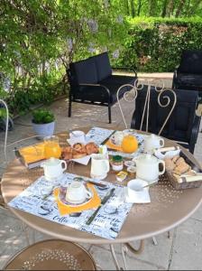 einen Tisch mit einem Frühstück mit Tee und Orangensaft in der Unterkunft Gîte, suite d'hote de charme, petit déjeuner compris in Firmi