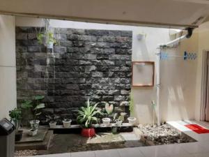 a room with a brick wall with potted plants at OKJ Homestay Syariah in Gondowulung