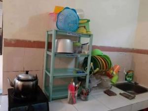 a kitchen counter with a shelf next to a sink at OKJ Homestay Syariah in Gondowulung