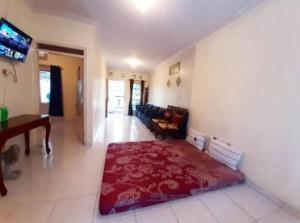 a living room with a red rug on the floor at OKJ Homestay Syariah in Gondowulung +1 photo