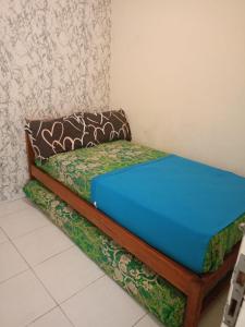 a bed sitting in a corner of a room at OKJ Homestay Syariah in Gondowulung