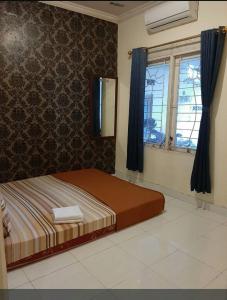 a bed in a room with a window and a bedvisor at OKJ Homestay Syariah in Gondowulung