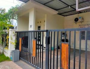 a building with a gate in front of a house at OKJ Homestay Syariah in Gondowulung