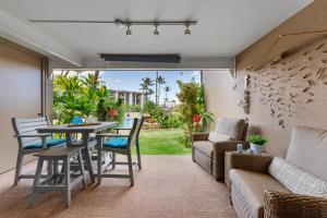 a living room with a table and chairs at Hale Ono Loa 104 in Kahana