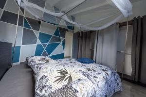 una camera da letto con un letto a baldacchino di Gray Coconut Sorbet, T3 tout équipé avec parking gratuit a Le Moule
