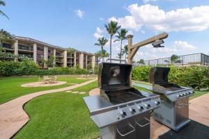 two stove topurgers in a park with a building at Hale Ono Loa 104 in Kahana
