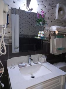 La salle de bains est pourvue d'un lavabo blanc et d'un miroir. dans l'établissement Towers by the Beach, à Ocho Rios