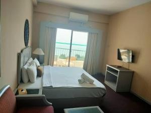 Una habitación de hotel con una cama y una ventana. en Rambo Paradise 1 bedroom, en Tanjung Bungah