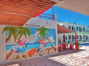 a mural on the side of a building with palm trees at Pelican Inn at Las Dunas Chelem in Chelem