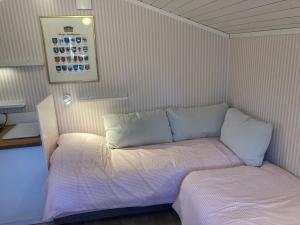 a small bed with two pillows in a room at Dunderfriggan på Möja in Möja +33 photos