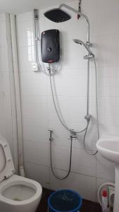 La salle de bains est pourvue d'une douche, de toilettes et d'un lavabo. dans l'établissement Homestay KNK, à Tawau