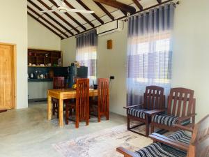 a dining room with a wooden table and chairs at Beach Escape in Arugam Bay