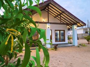 a house with a thatched roof at Beach Escape in Arugam Bay