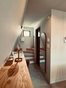 a room with a wooden table and a staircase at TRIGON HOUSE HOTEL KOFU in Kofu