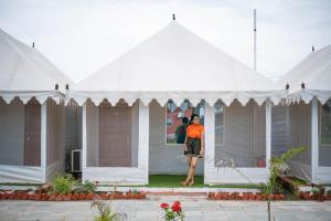 uma mulher parada no meio de uma tenda branca em The Royal Heritage Tent Resort- Statue of Unity em Navgam